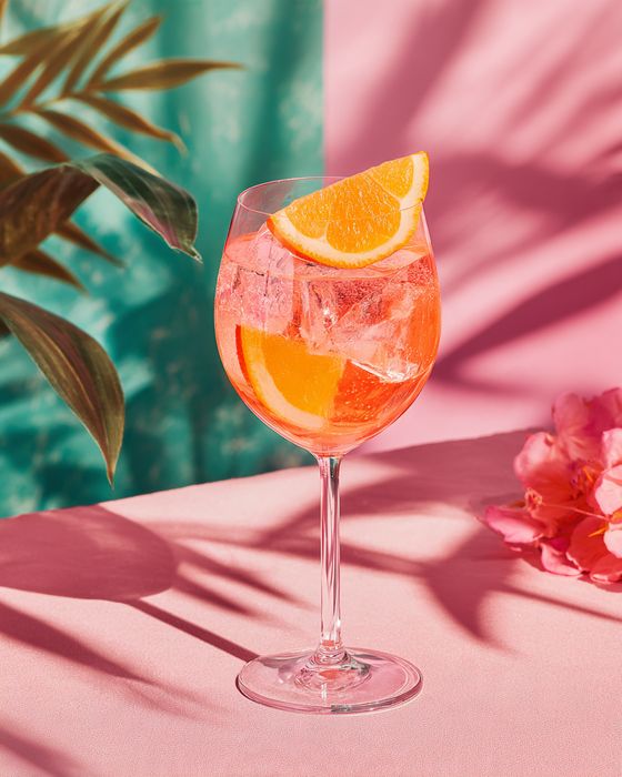 Pink Dream Spritz cocktail: wine glass, garnished with orange slice